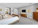 Bright bedroom with neutral walls, carpet floors, modern lighting, and a glimpse into the bathroom at 286 Shaded Canyon Dr, Henderson, NV 89012