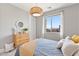 Bright bedroom with a cozy bed, wooden dresser, and a lovely view of the city skyline at 286 Shaded Canyon Dr, Henderson, NV 89012