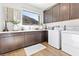 Modern laundry room with shaker cabinets, granite counters, stainless steel sink, and mountain views at 286 Shaded Canyon Dr, Henderson, NV 89012