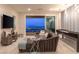 Cozy living space with a large sectional, game table, contemporary lighting, and a sweeping city view from the sliding glass door at 286 Shaded Canyon Dr, Henderson, NV 89012