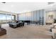 Large living room boasts a comfortable sofa, piano, patterned accent wall, and expansive windows showcasing scenic views at 286 Shaded Canyon Dr, Henderson, NV 89012