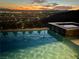 Evening shot of a swimming pool and hot tub, softly illuminated, with a mountain view at dusk in the distance at 286 Shaded Canyon Dr, Henderson, NV 89012