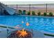 Outdoor pool area featuring a fire pit, slide, and city views in the background at 286 Shaded Canyon Dr, Henderson, NV 89012