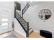 Modern staircase features sleek black railings, stylish carpeting, a decorative round mirror, and light wood flooring at 286 Shaded Canyon Dr, Henderson, NV 89012