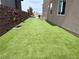 Spacious side yard featuring lush artificial turf, mature trees, and attractive landscaping at 286 Shaded Canyon Dr, Henderson, NV 89012