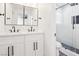 Stylish bathroom featuring a double vanity, decorative mirrors, and a tiled walk-in shower at 3017 Jamestown Way, Las Vegas, NV 89102