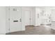 Bright entryway featuring a white front door and complementary interior door with modern white cabinets and wood flooring at 3017 Jamestown Way, Las Vegas, NV 89102