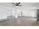 Bright living room with wood flooring, ceiling fan, and open layout, offering seamless flow into the kitchen and entryway at 3017 Jamestown Way, Las Vegas, NV 89102