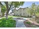 Beautiful exterior with a lush green lawn, mature trees, and a sidewalk at 3404 Winterhaven St # 204, Las Vegas, NV 89108
