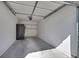 A clean, empty garage with painted walls and ceiling, as well as concrete flooring and shelving for extra storage at 3404 Winterhaven St # 204, Las Vegas, NV 89108