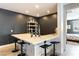 Wet bar area featuring counter seating, a sink, sleek decor and modern lighting at 3458 W Agate Ave, Las Vegas, NV 89139