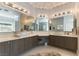 Bathroom featuring dual sinks, quartz counters, framed mirrors and unique lighting fixtures at 3458 W Agate Ave, Las Vegas, NV 89139