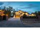 A front elevation of a well-lit, two-story home with a landscaped front yard and a gated driveway at 3458 W Agate Ave, Las Vegas, NV 89139