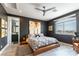 Modern main bedroom with dark walls, a ceiling fan, large window and ensuite bathroom at 3458 W Agate Ave, Las Vegas, NV 89139