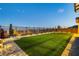 Backyard featuring green lawn, a perimeter fence, and tasteful landscaping at 350 Gandara St, Las Vegas, NV 89138