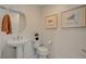 Powder room with pedestal sink, framed artwork and a decorative round mirror at 350 Gandara St, Las Vegas, NV 89138