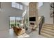 Well-lit living room with a stone fireplace, large windows, and sliding glass doors to outdoor area at 350 Gandara St, Las Vegas, NV 89138