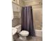Bathroom featuring tiled shower with caddy and seat, toilet, sink, and a grey shower curtain at 355 Gracious Way, Henderson, NV 89011