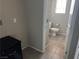 Neutral toned half bathroom with tiled floor, and a view of the toilet and window at 355 Gracious Way, Henderson, NV 89011