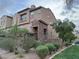 Charming multi-story townhouse featuring stone accents and desert landscaping, with an attached garage at 355 Gracious Way, Henderson, NV 89011