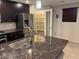 A view of a kitchen featuring granite countertops, stainless steel appliances, and a pantry at 355 Gracious Way, Henderson, NV 89011