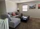 Well-lit living room with a plush gray sectional sofa, coffee table, and artwork at 355 Gracious Way, Henderson, NV 89011
