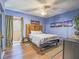Bedroom with light blue walls, dark wood floors, and light-blocking curtains at 438 Las Casitas Way, Las Vegas, NV 89121