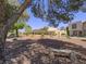 A view of tan townhomes, landscaping and trees with a wooden bench in the foreground at 438 Las Casitas Way, Las Vegas, NV 89121