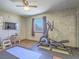 Exercise room with an elliptical machine, mounted television, and wood-look floors at 438 Las Casitas Way, Las Vegas, NV 89121