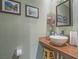 Stylish powder room with vessel sink, wood counter, and decorative artwork at 438 Las Casitas Way, Las Vegas, NV 89121