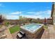 A relaxing hot tub on a paved patio, landscaped backyard and clear blue skies at 4505 Meline Ave, North Las Vegas, NV 89084