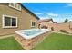 Inviting backyard hot tub with decorative stone detail, surrounded by artificial turf at 4505 Meline Ave, North Las Vegas, NV 89084