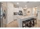 Modern kitchen featuring a granite-topped island with seating, stainless steel appliances, and white cabinets at 4505 Meline Ave, North Las Vegas, NV 89084