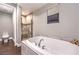 A bathroom featuring a white tub, a window, a walk-in shower and a toilet in its own enclosure at 47 Strada Principale, Henderson, NV 89011