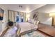 Relaxing bedroom featuring three windows, a modern light fixture, light gray walls and wood flooring at 47 Strada Principale, Henderson, NV 89011