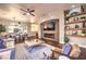 Open-concept living room featuring a fireplace, shelving, and seamless flow to the dining area at 47 Strada Principale, Henderson, NV 89011