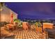 Outdoor patio area with a dining set, sun umbrella, and panoramic mountain views at twilight at 47 Strada Principale, Henderson, NV 89011
