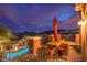 Relaxing outdoor patio with dining set, red umbrella, and scenic views of the city lights at 47 Strada Principale, Henderson, NV 89011
