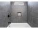 This bathroom features gray tiling, a tub, and a shower head at 4981 Alondra Dr, Las Vegas, NV 89118