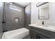 Gray-tiled bathroom with modern vanity and shower/tub with matte black fixtures at 4981 Alondra Dr, Las Vegas, NV 89118