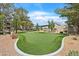Enjoy the community putting green and outdoor seating area with lush landscaping and mature trees at 5250 S Rainbow Blvd # 1144, Las Vegas, NV 89118