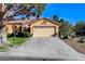 Single-story home boasts a two-car garage, manicured lawn, and desert landscaping for low maintenance at 5541 Port Barrington Way, Las Vegas, NV 89130