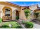 Inviting front porch features seating, lush greenery, and an arched entryway to the single-story home at 5541 Port Barrington Way, Las Vegas, NV 89130