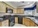 The kitchen has wooden cabinets, black countertops, a black refrigerator, a gas stove, and a dishwasher at 5541 Port Barrington Way, Las Vegas, NV 89130