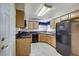 The kitchen has wooden cabinets, black countertops, a black refrigerator, a gas stove, and a dishwasher at 5541 Port Barrington Way, Las Vegas, NV 89130