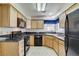The kitchen has wooden cabinets, black countertops, a black refrigerator, a gas stove, and a dishwasher at 5541 Port Barrington Way, Las Vegas, NV 89130