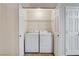 Efficient laundry area features a washer, dryer, and convenient overhead shelving at 5541 Port Barrington Way, Las Vegas, NV 89130