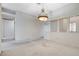 Bright living room featuring neutral carpet and a decorative chandelier at 5541 Port Barrington Way, Las Vegas, NV 89130