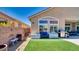 Well-kept backyard with artificial turf, seating area, BBQ and dog house at 5820 Amber Station Ave, Las Vegas, NV 89131