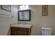 Bathroom featuring a vanity with granite countertop, framed mirror, and a nearby toilet at 5820 Amber Station Ave, Las Vegas, NV 89131